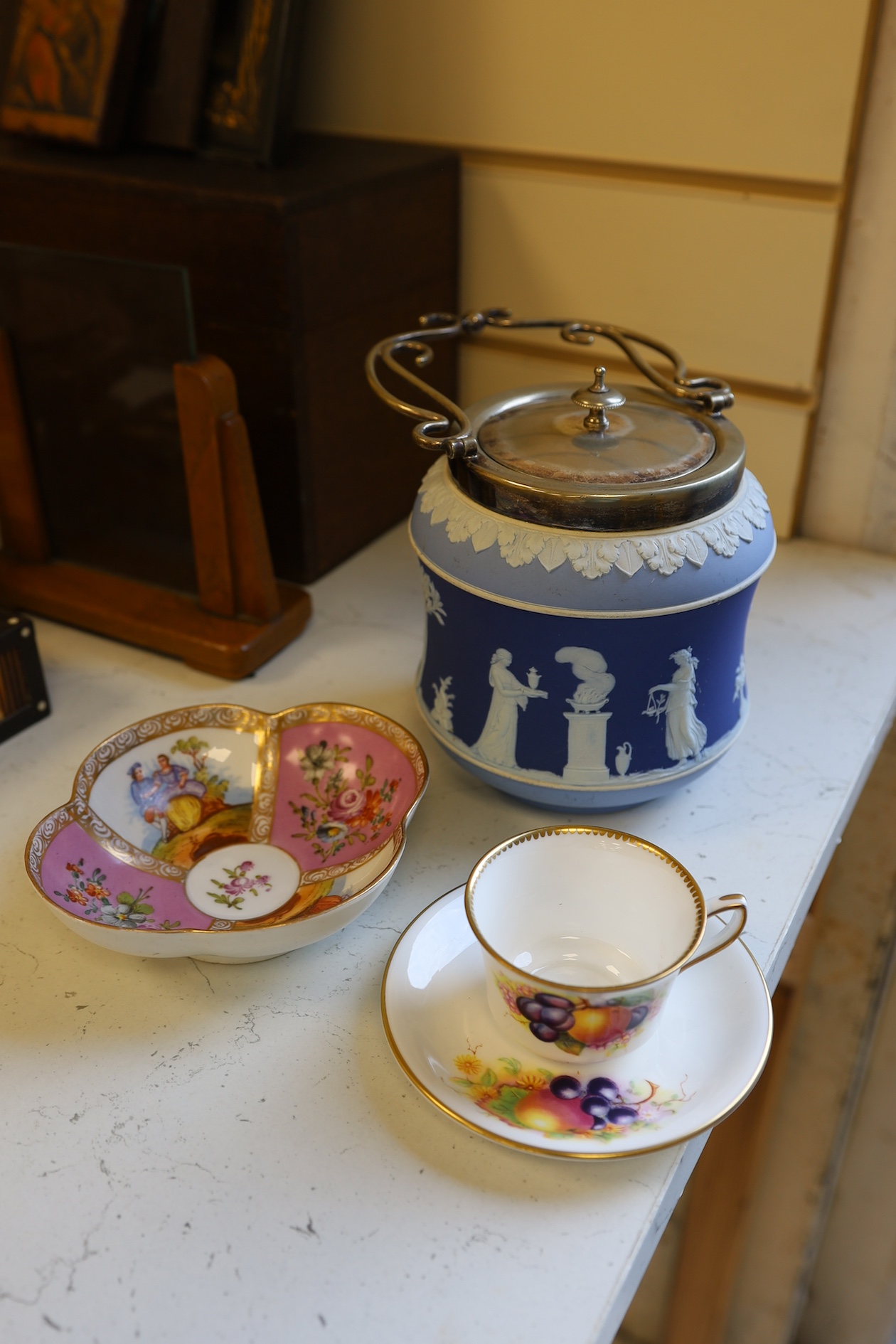 A Wedgwood three colour biscuit barrel with plated rim and handle, a Royal Worcester cup and saucer and a Dresden shaped bowl, biscuit barrel 17cm high. Condition - good